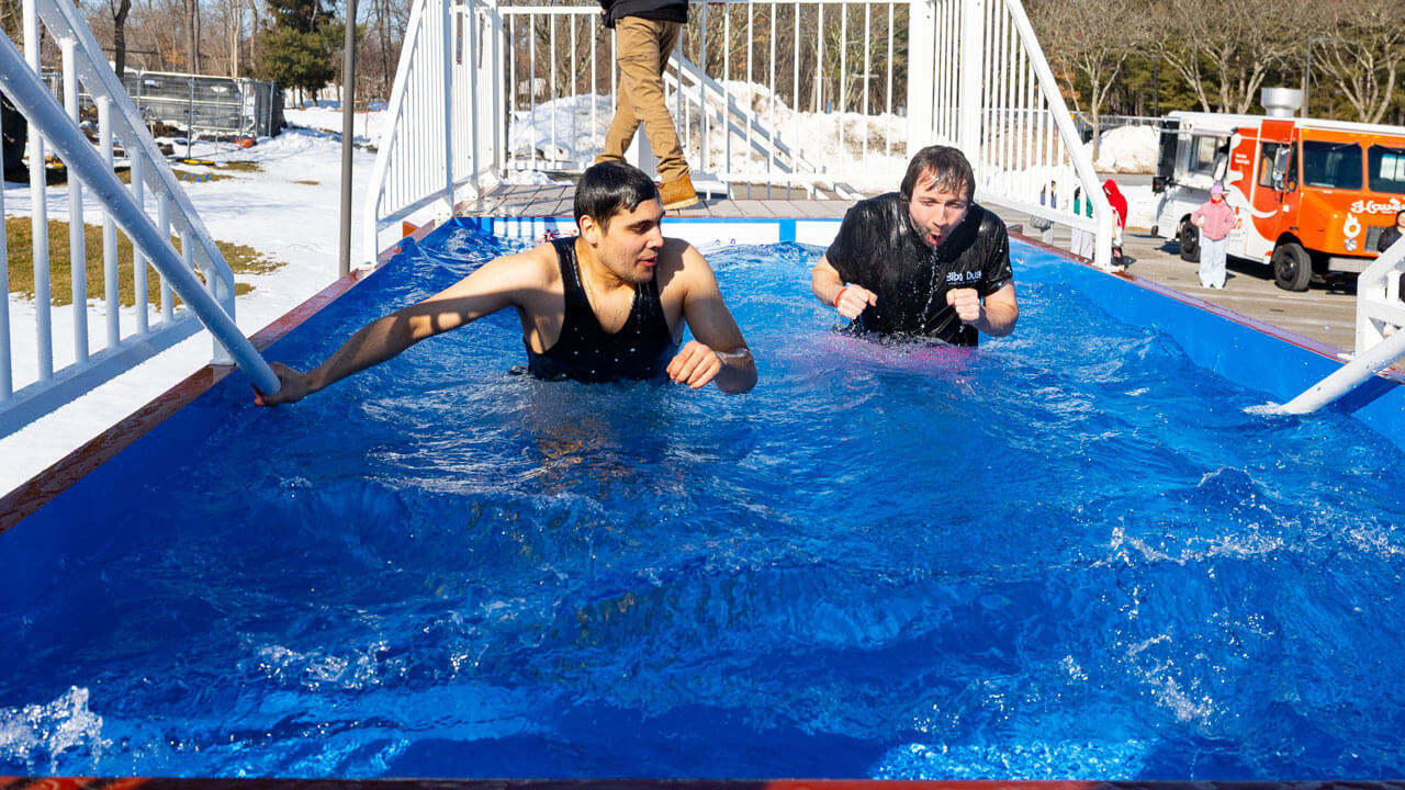 Students and participants stand in freezing dunk tank