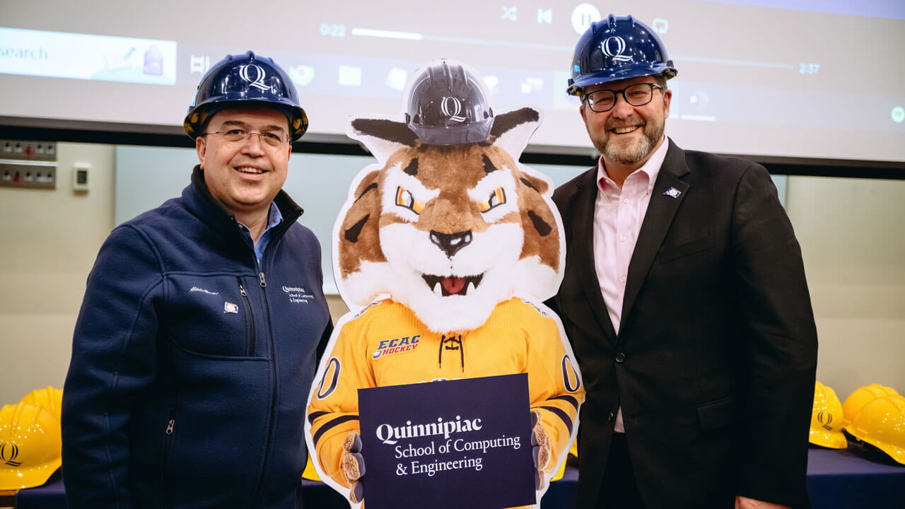 Engineer professors wearing "Q" hard hats and posing with Boomer the Bobcat