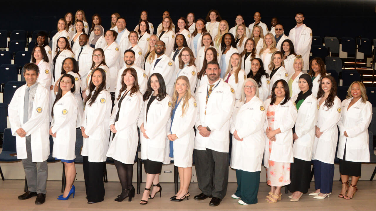 Students smile in their white coats at the School of Nursing’s white coat ceremony celebrating MSN Nurse Practitioners