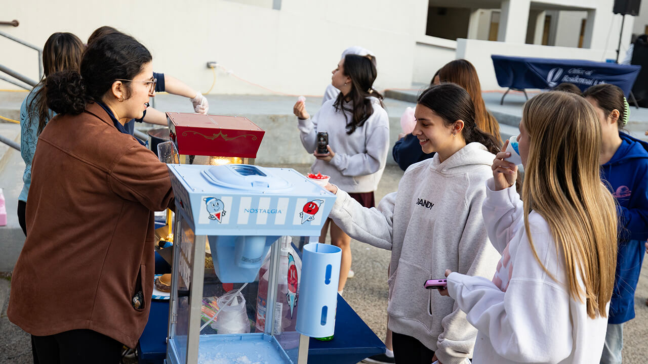 Students serving other students popcorn at Bobcat Block Party