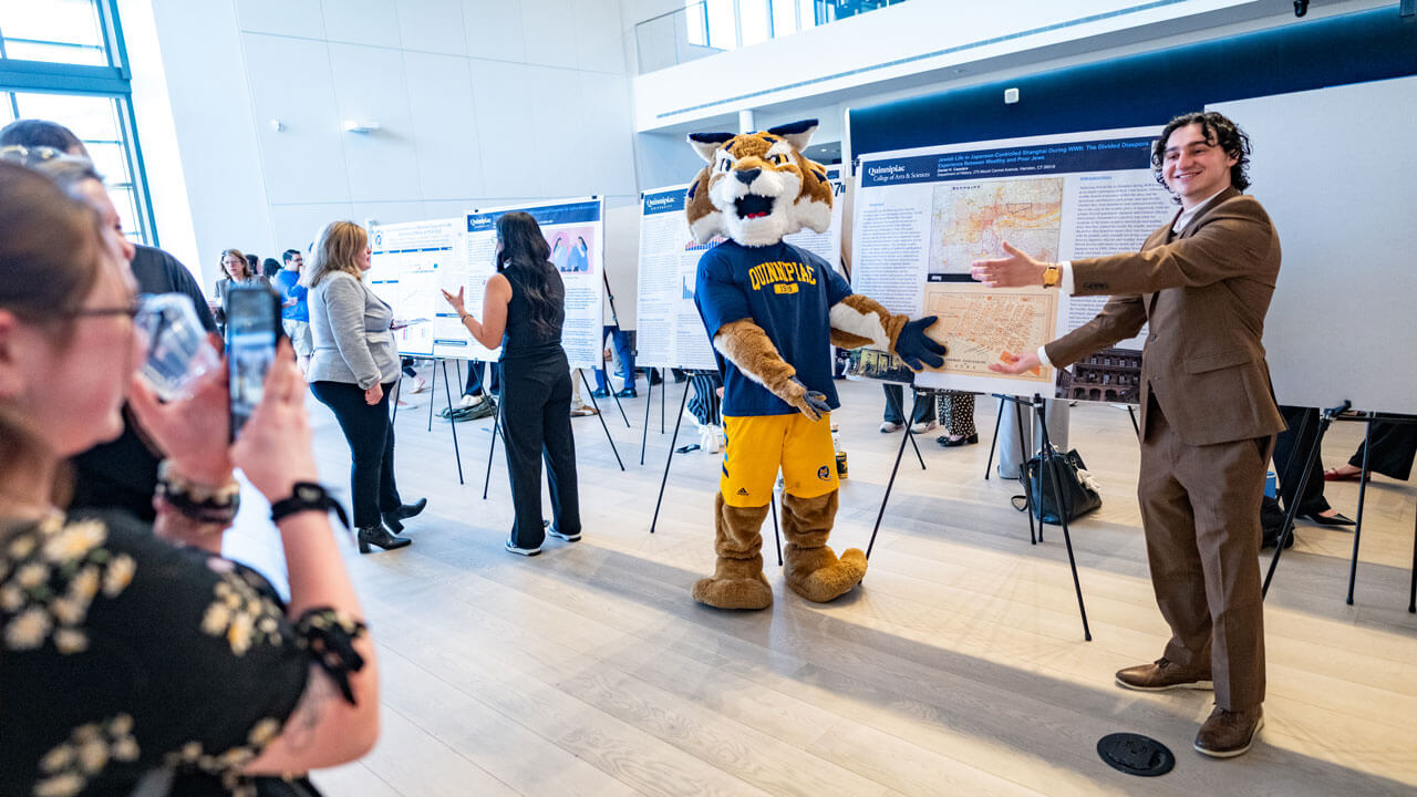 Student pose with Boomer in front of their research findings