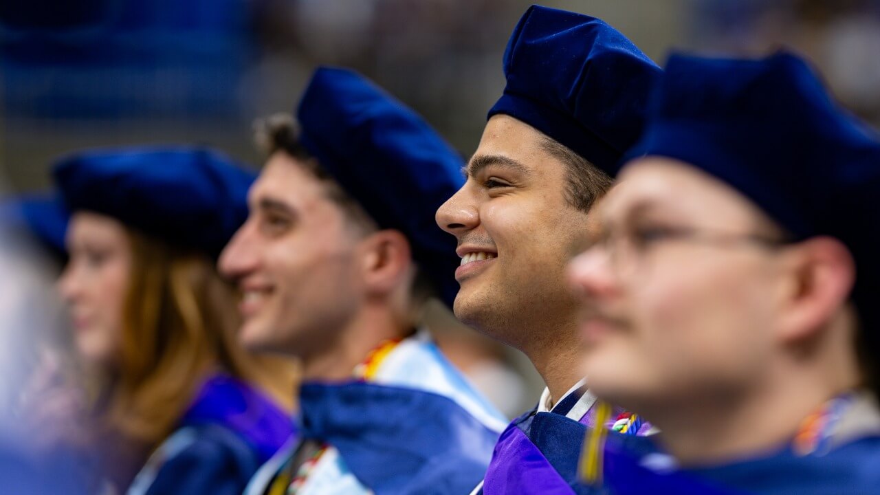 Graduates smile as they look forward.