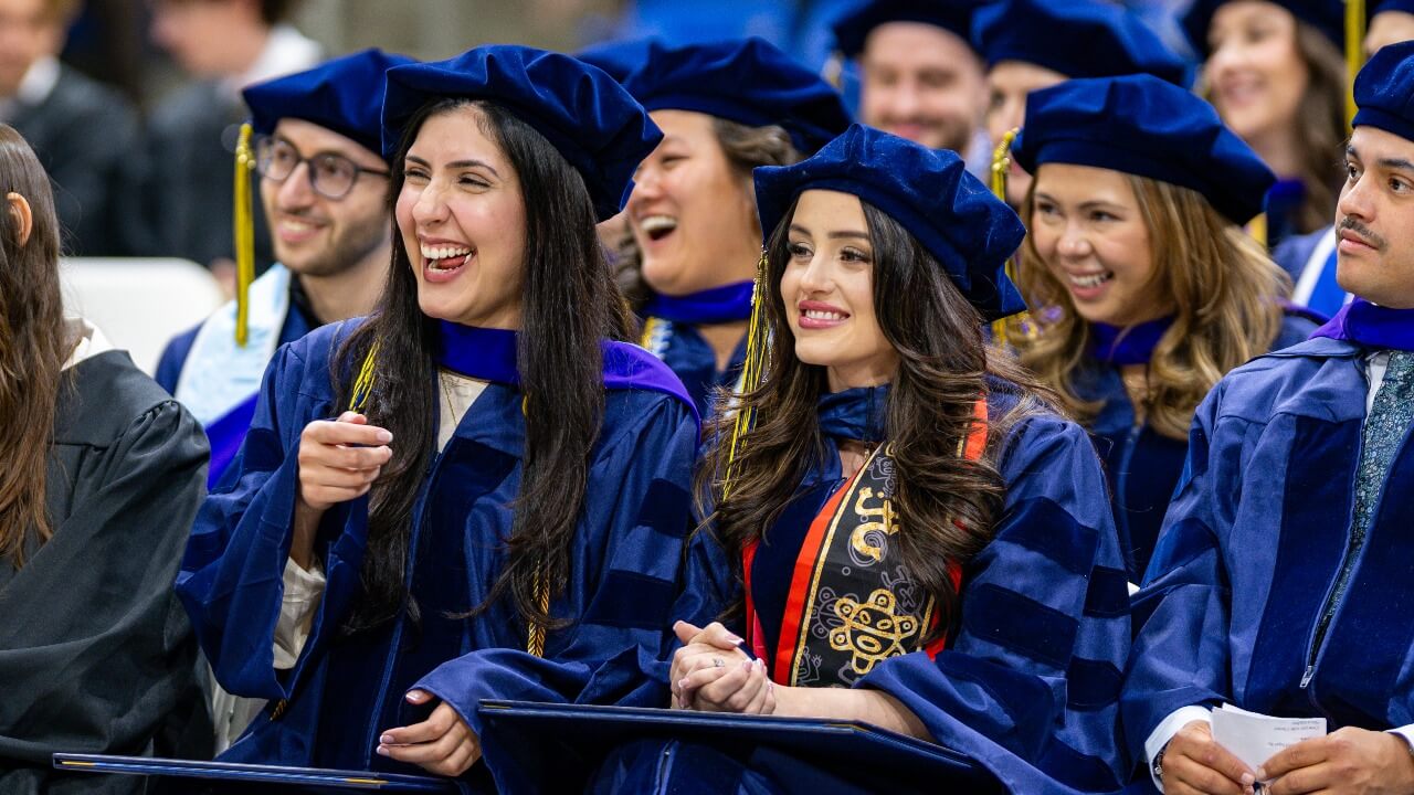 Crowd of graduates laugh.