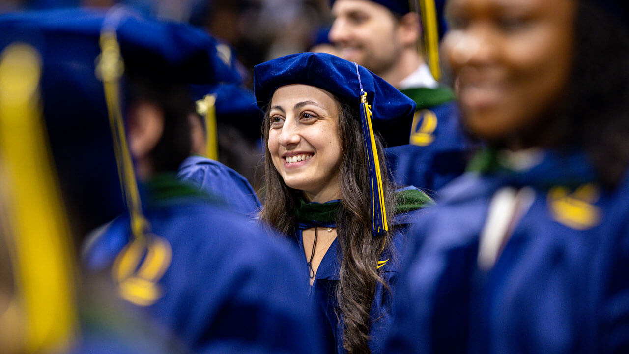Class of 2026 School of Medicine graduate smiles bright in her cap and gown