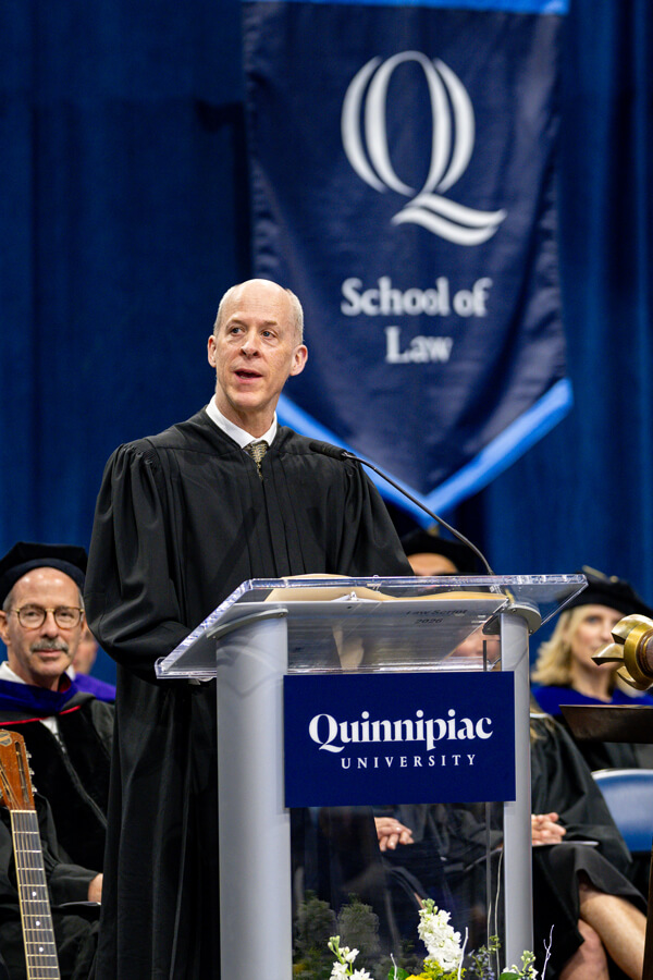 Keynote speaker Shea speaking at the podium and looking towards his right