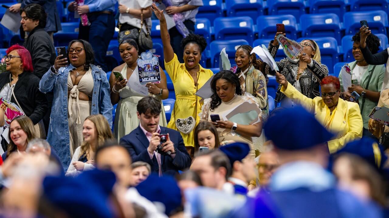 Crowd cheers for graduates.
