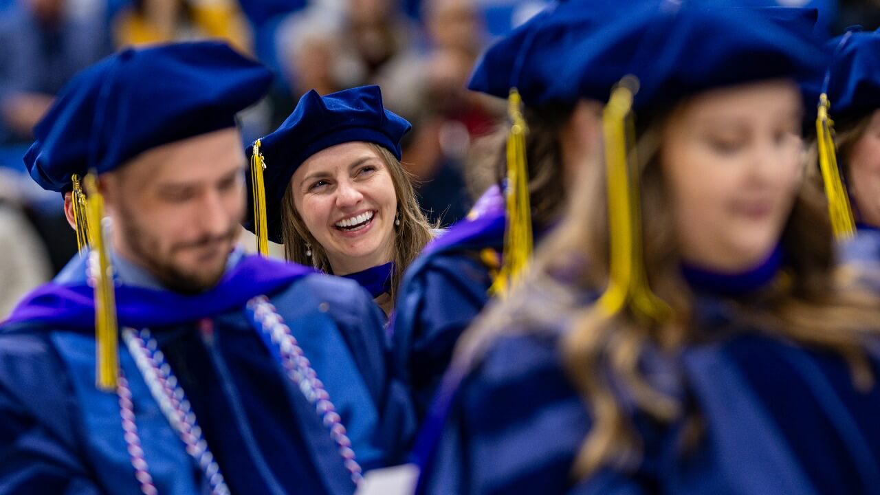 Graduate smiles in the crowd.