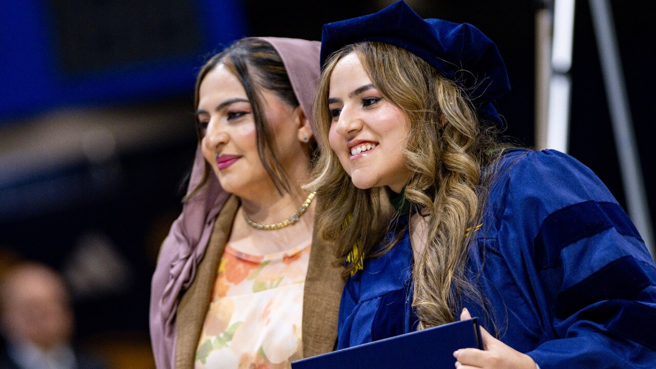 Graduate smiles with their loved one