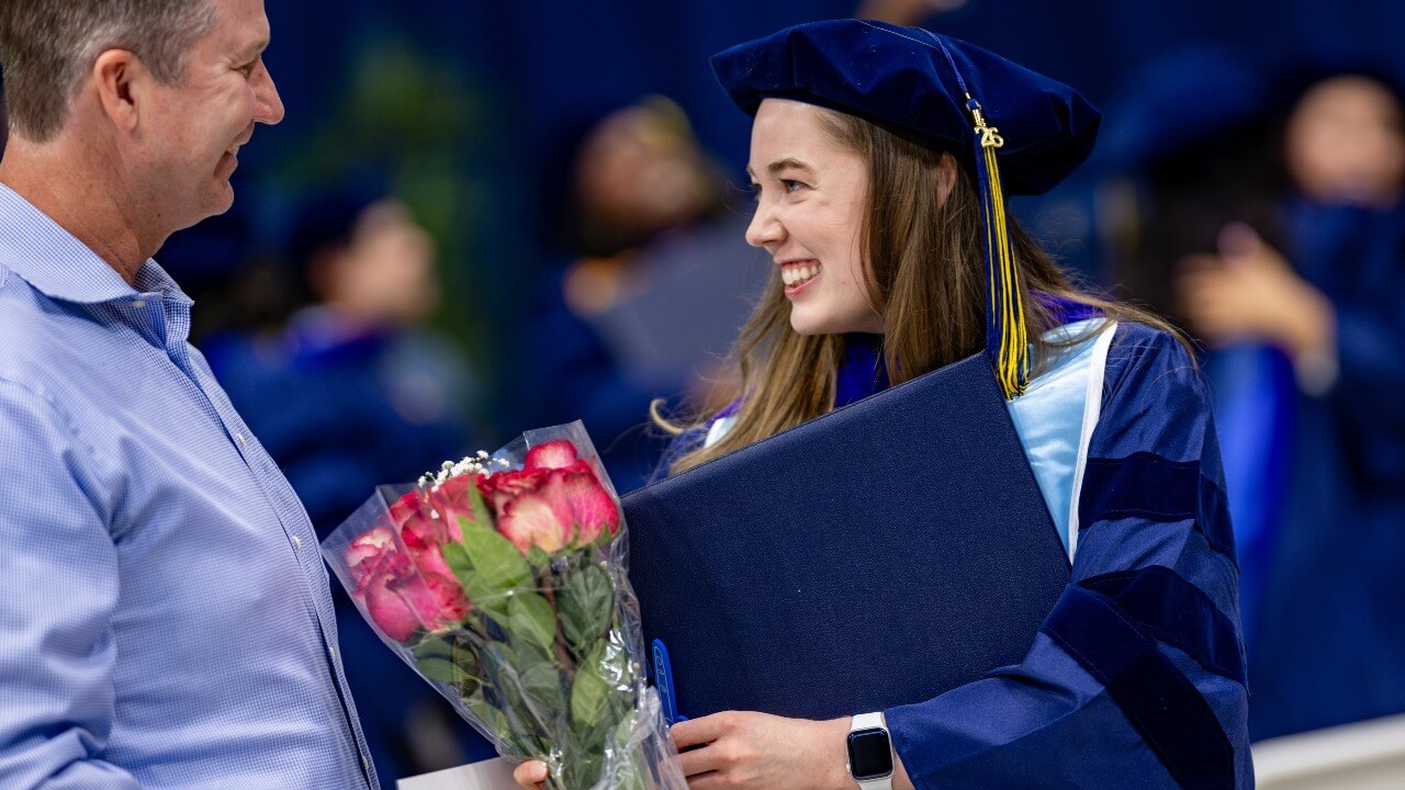 Graduate receives flowers from loved one after commencement