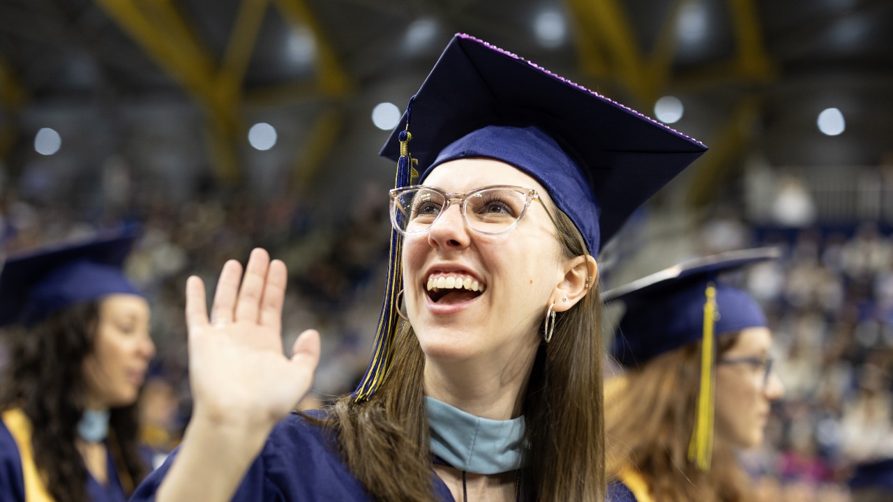 Graduate wearing cap looks up and smiles