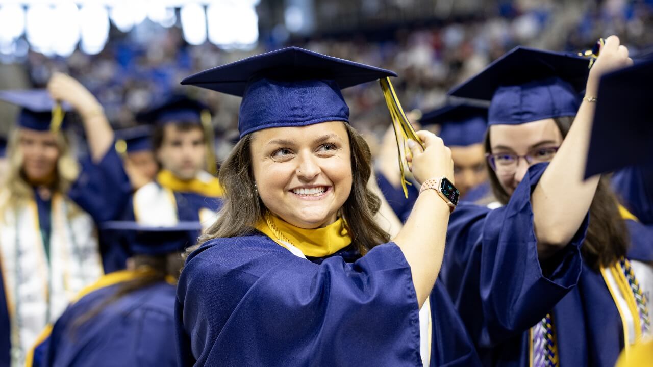 Student moves their tassel from the right to the left, symbolizing their graduation