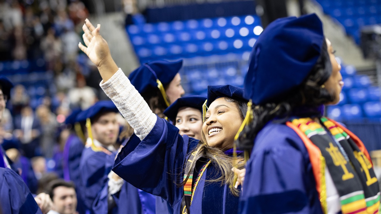 Graduating student waves to the crowd