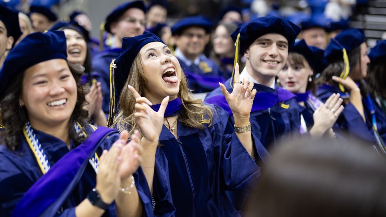 Students cheering at Commencement and graduate makes a funny face