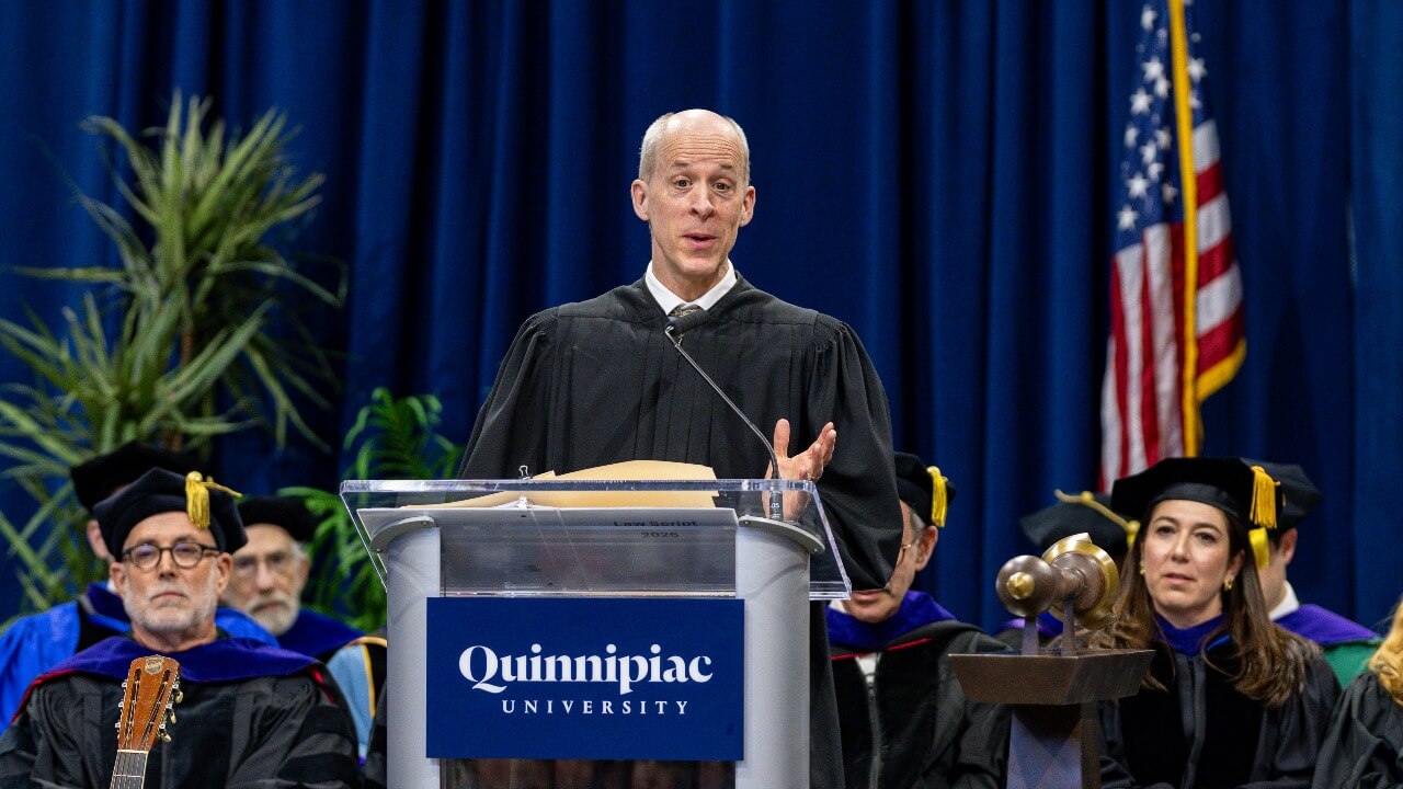 Keynote speaker standing at podium and speaking out to crowd
