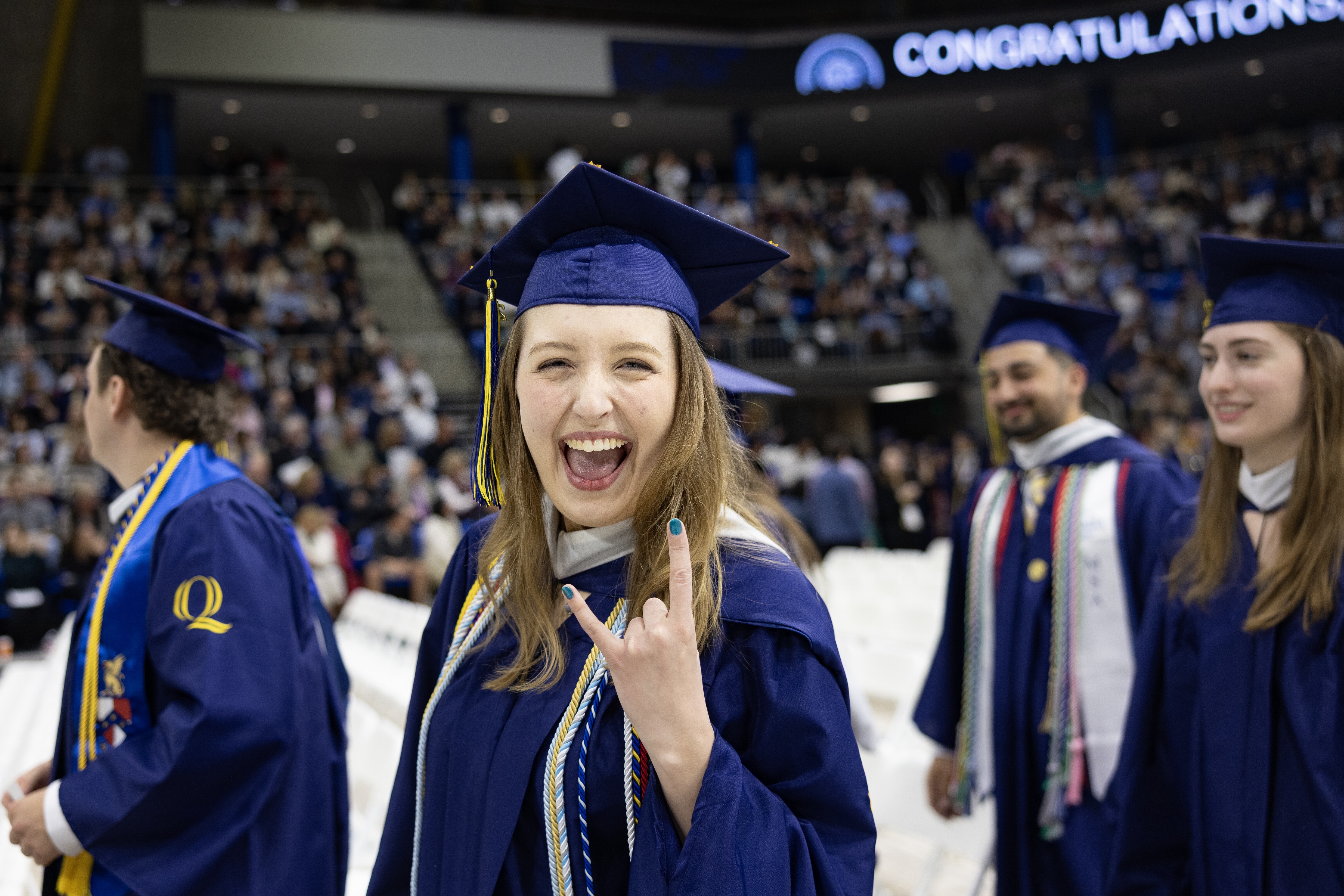 Graduate holds up hand sign with excitement