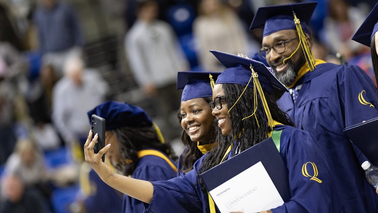Graduates stand together to take a selfie during commencement day