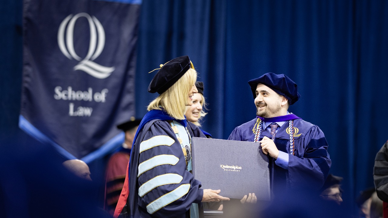 Marie Hardin hands graduating student their diploma