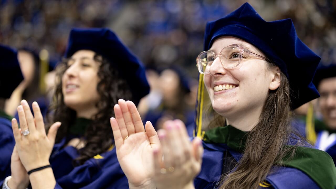 School of Medicine graduates smiling and clapping