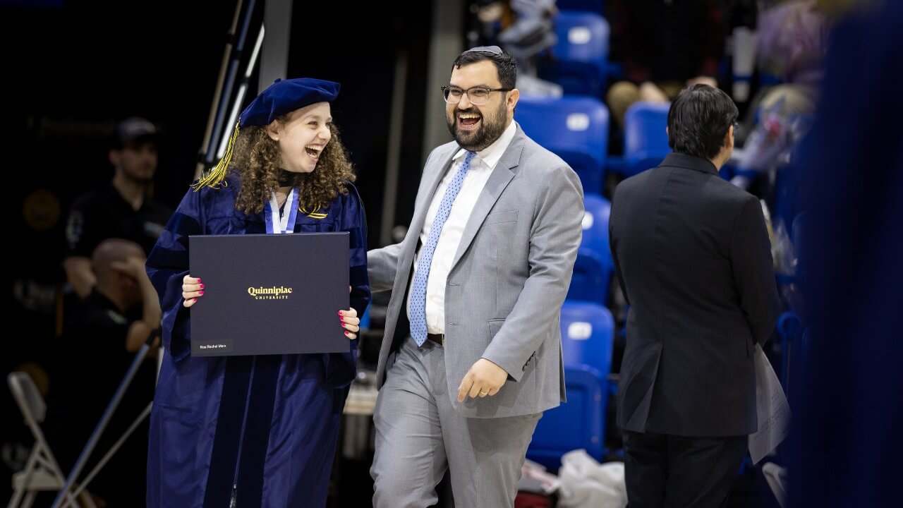 Graduate and guest smiling together