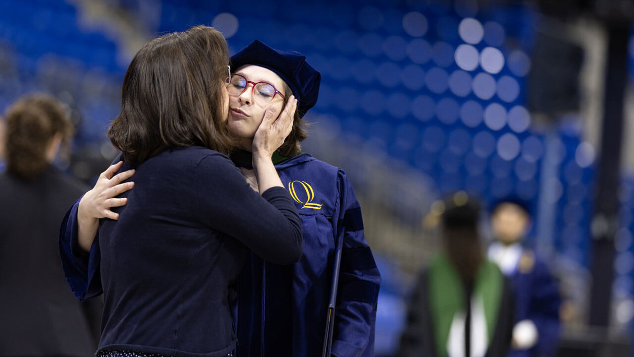 2026 School of Medicine graduate hugging a loved one at Commencement
