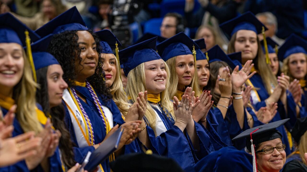 Graduates smile at Commencement