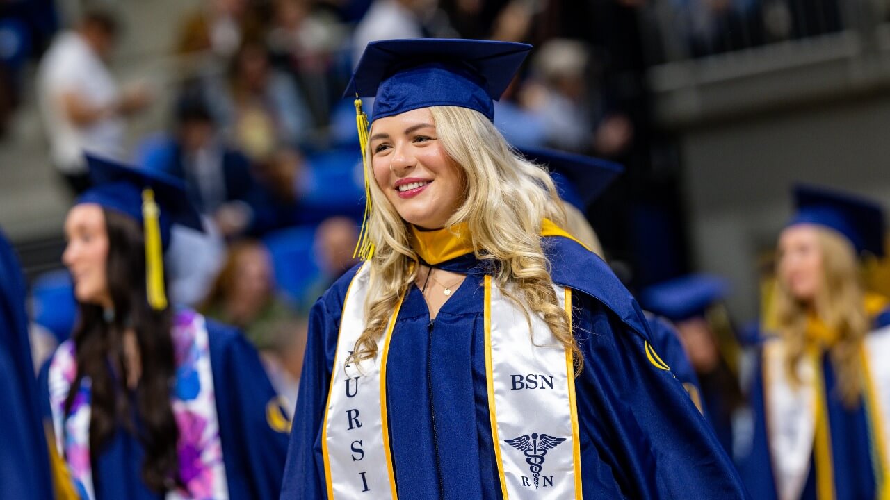 Graduate smiles in excitement during graduation ceremony