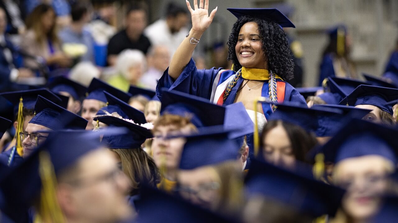 Graduate waving in the crowd