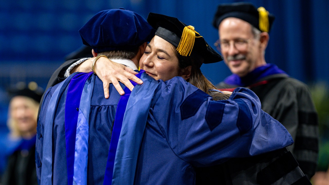 A graduate hugs professor at School of Law ceremony