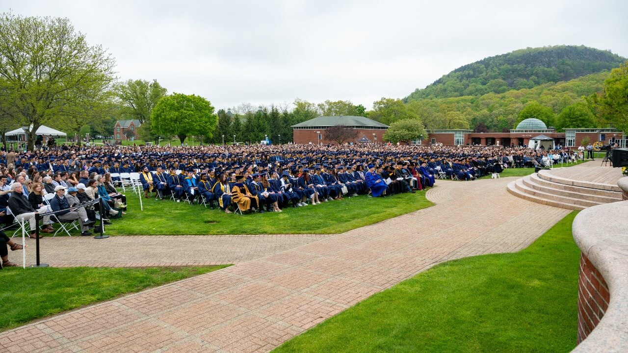 A wide shot of the Quad filled with graduates and their families