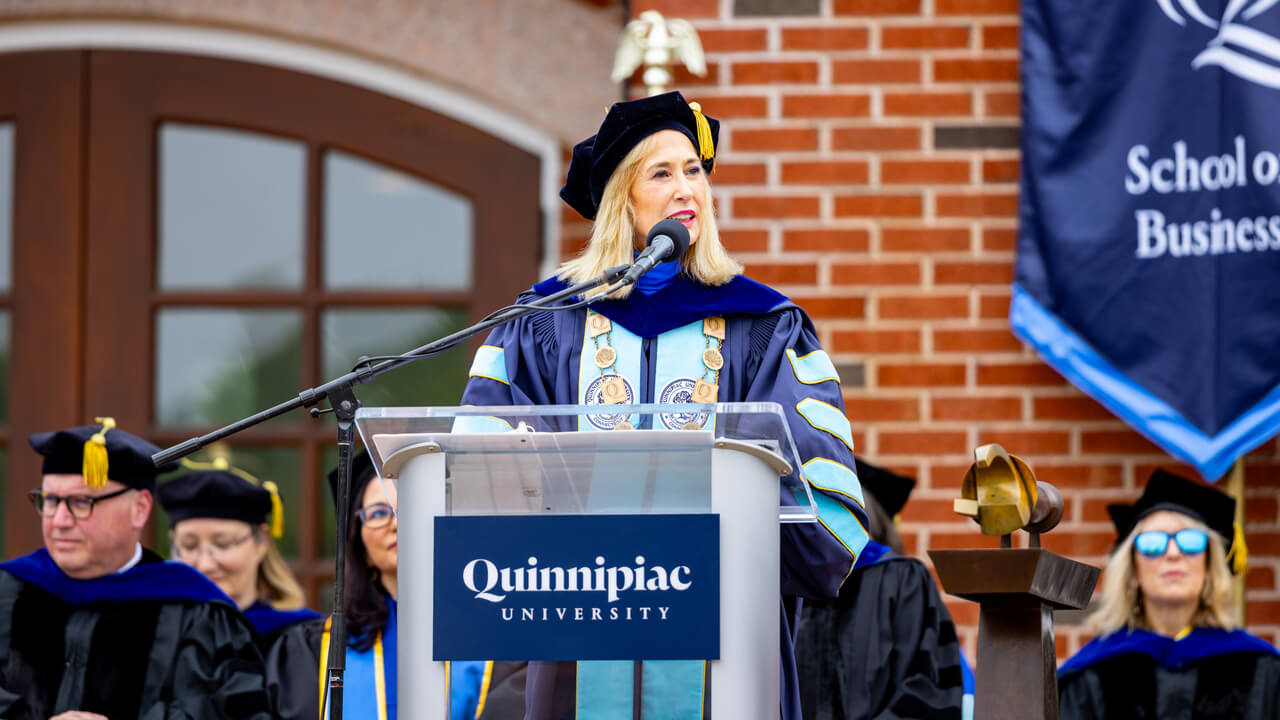 Marie Hardin speaks at the podium on the library steps with administrators behind her