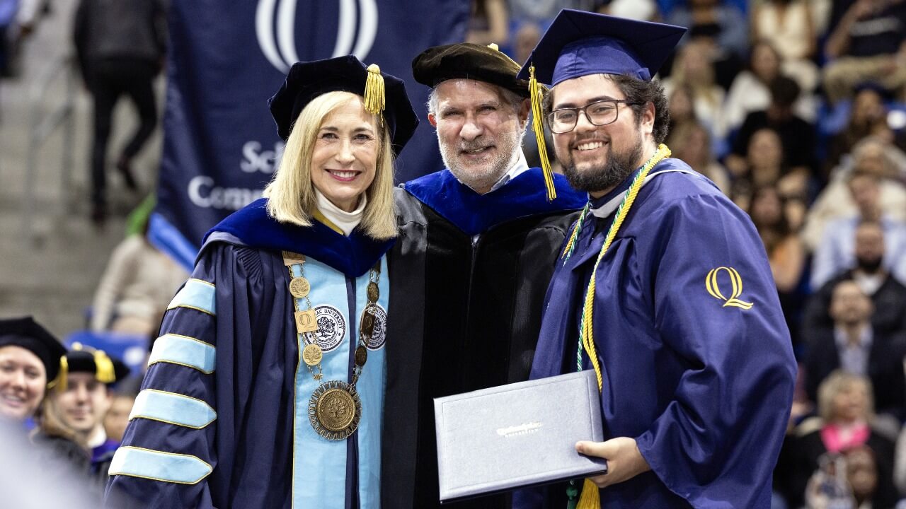 President Marie Hardin posing with a graduate holding their diploma
