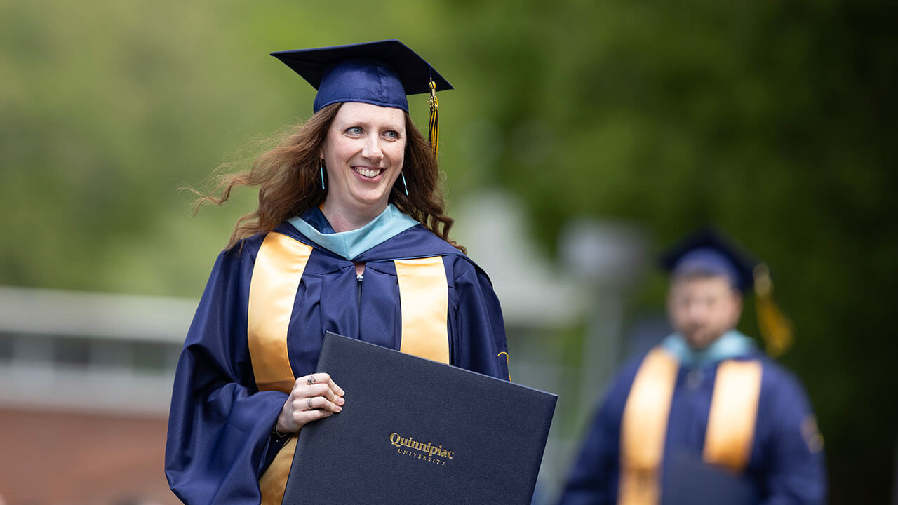 graduate smiles with diploma