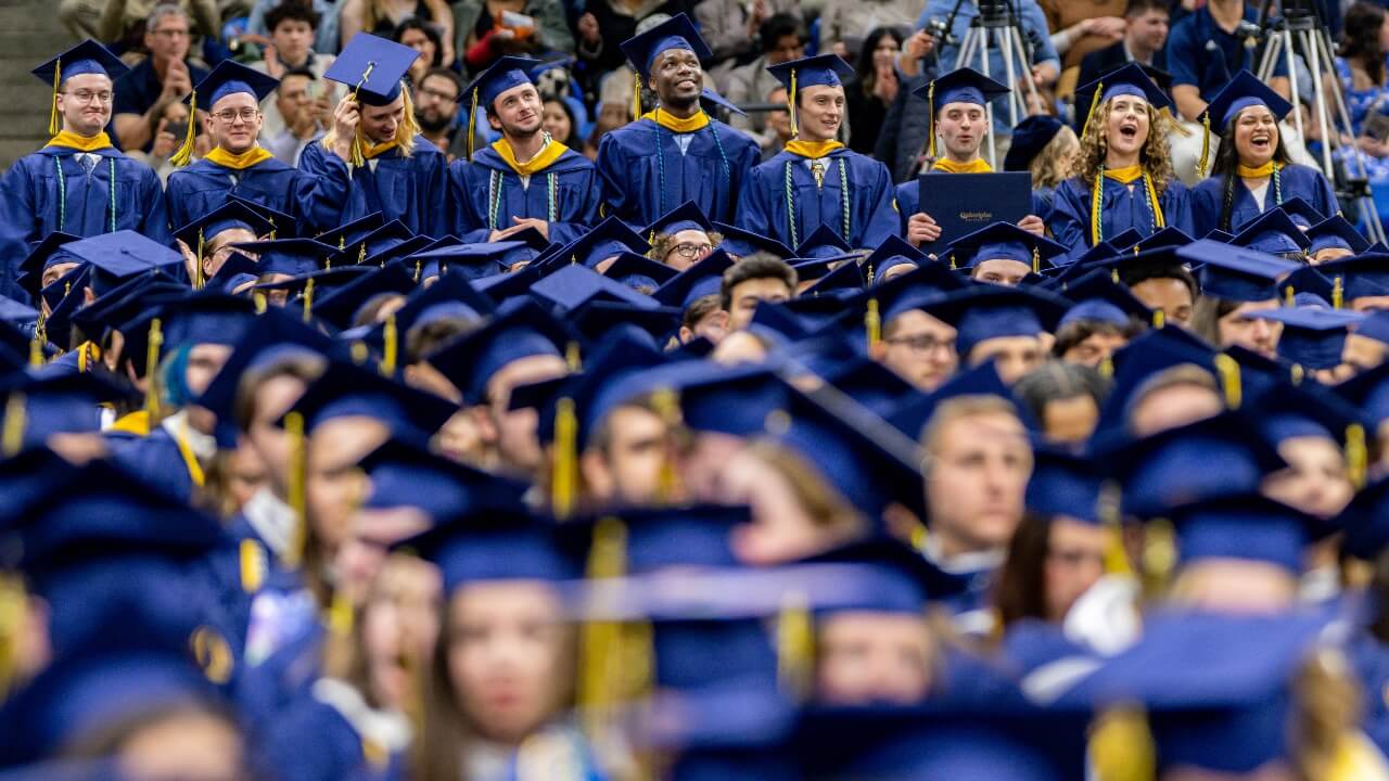 Graduates sit at Commencement with excitement