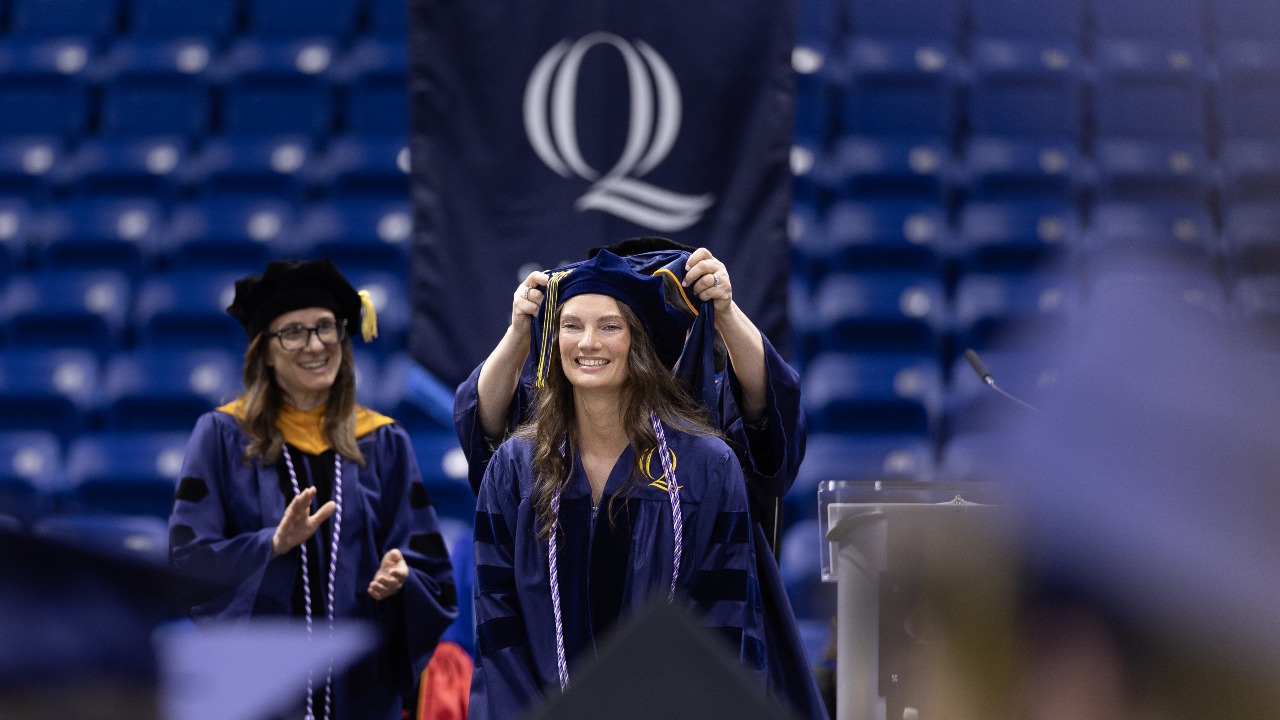 Graduating student gets hooded at commencement