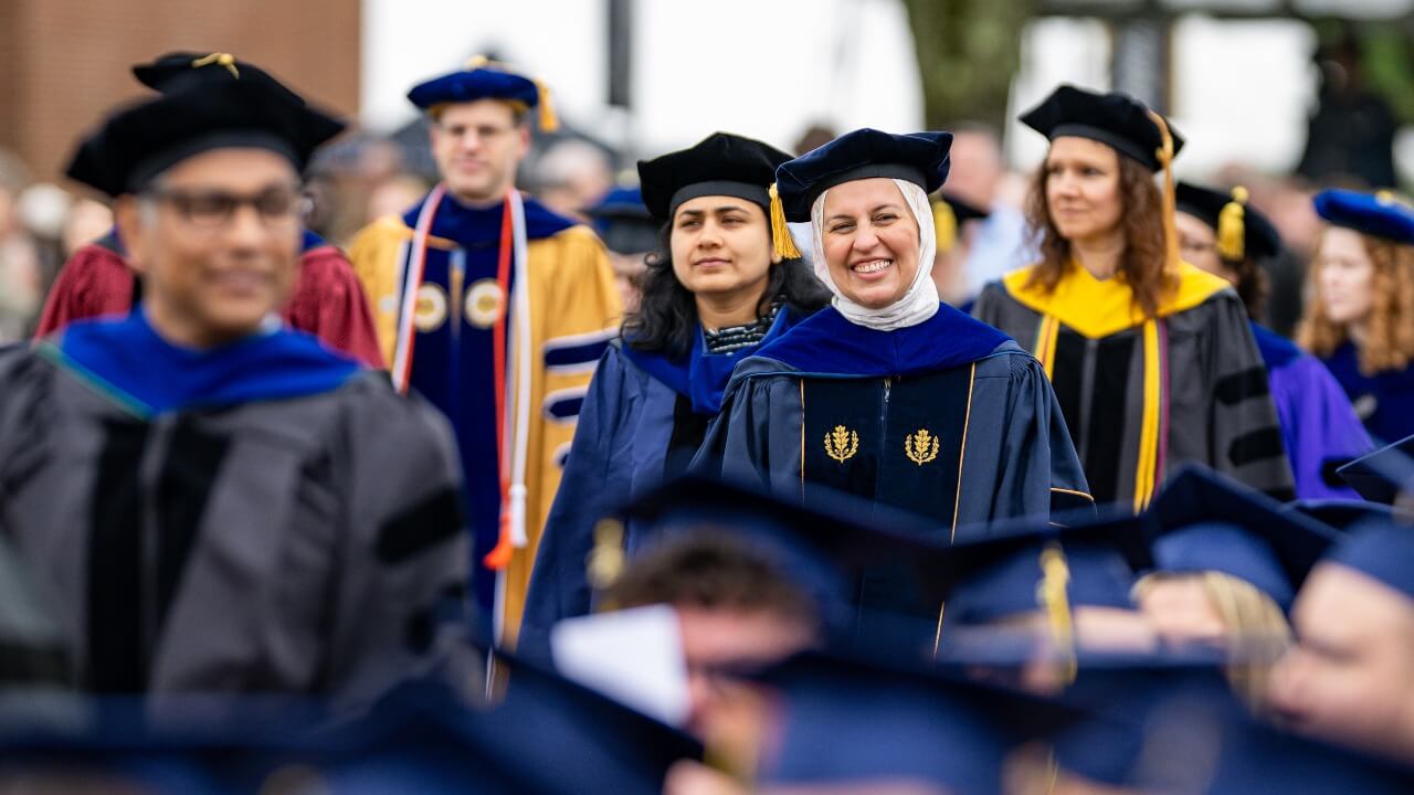 the faculty all together smiling and in their robes