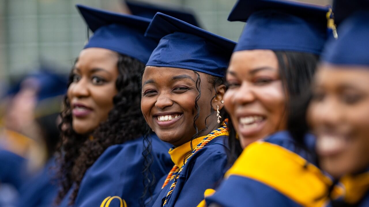 shot of 4 graduates one is looking at the camera and smiling