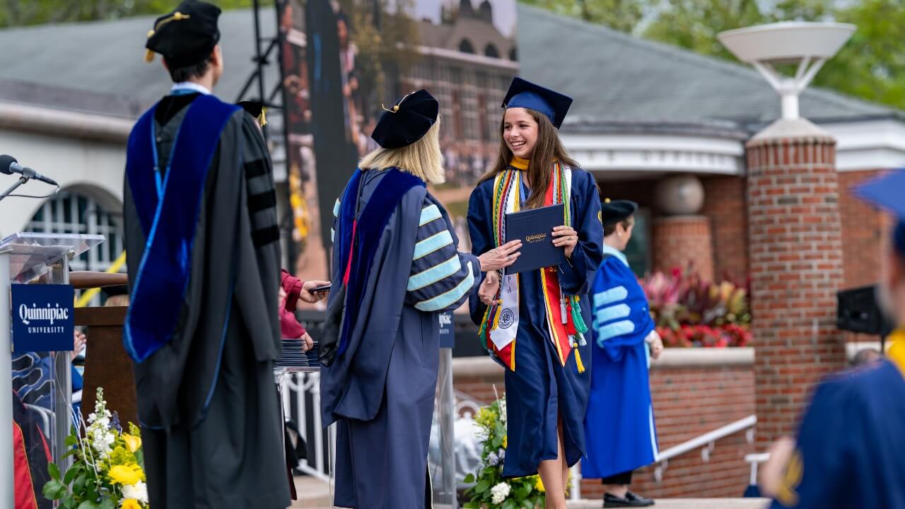 President Marie Hardin giving a graduate her diploma