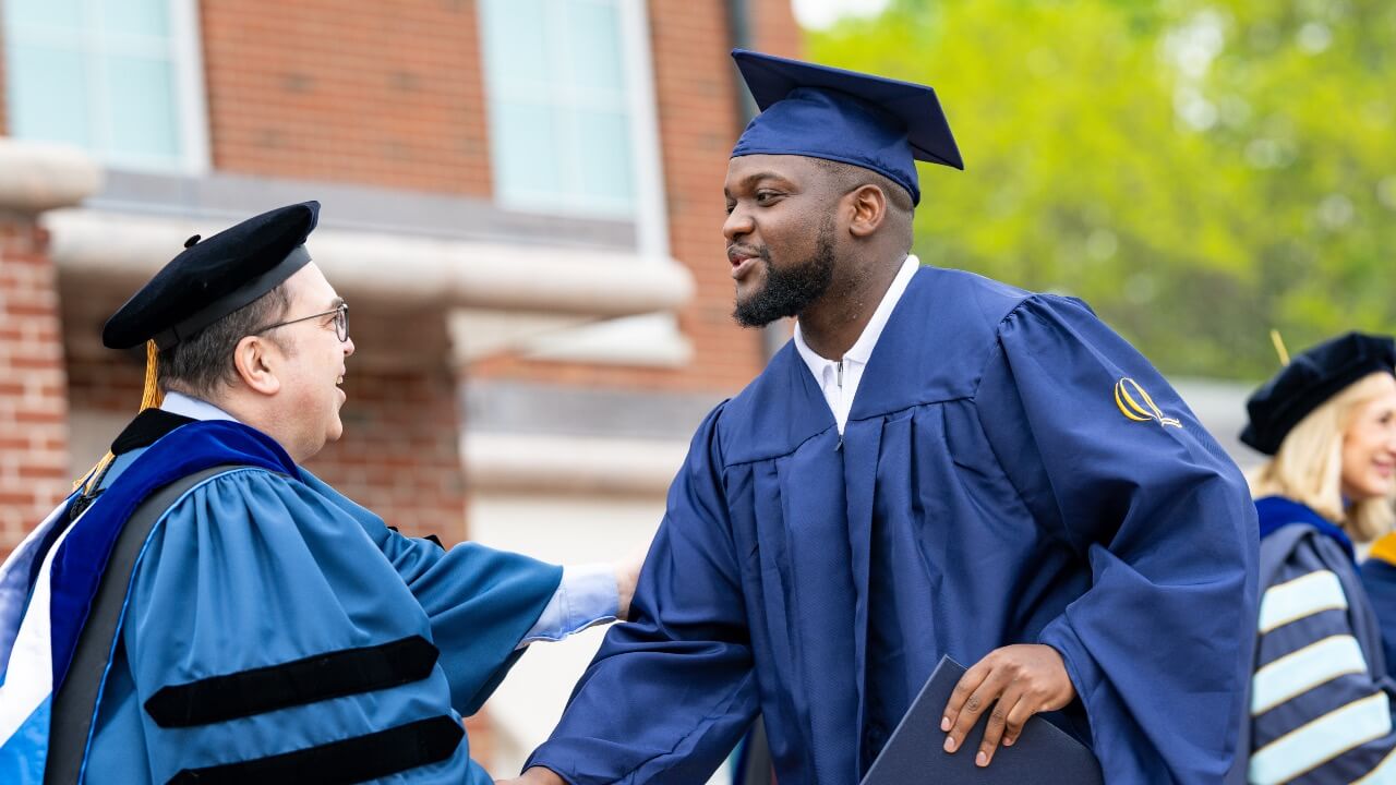 Graduate shakes hands with Dean Tashkin Kocak
