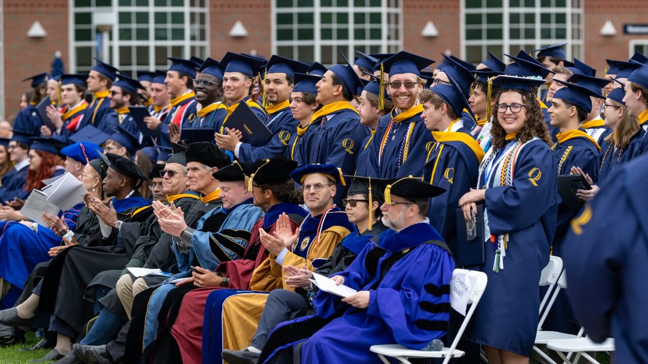 Graduates stand behind professors of the School of Computing and Engineering