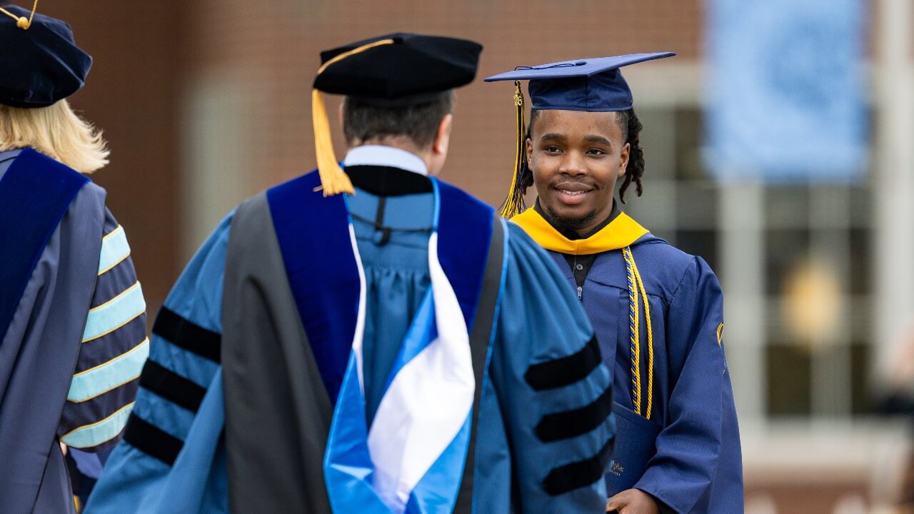 Graduate shakes hand on stage