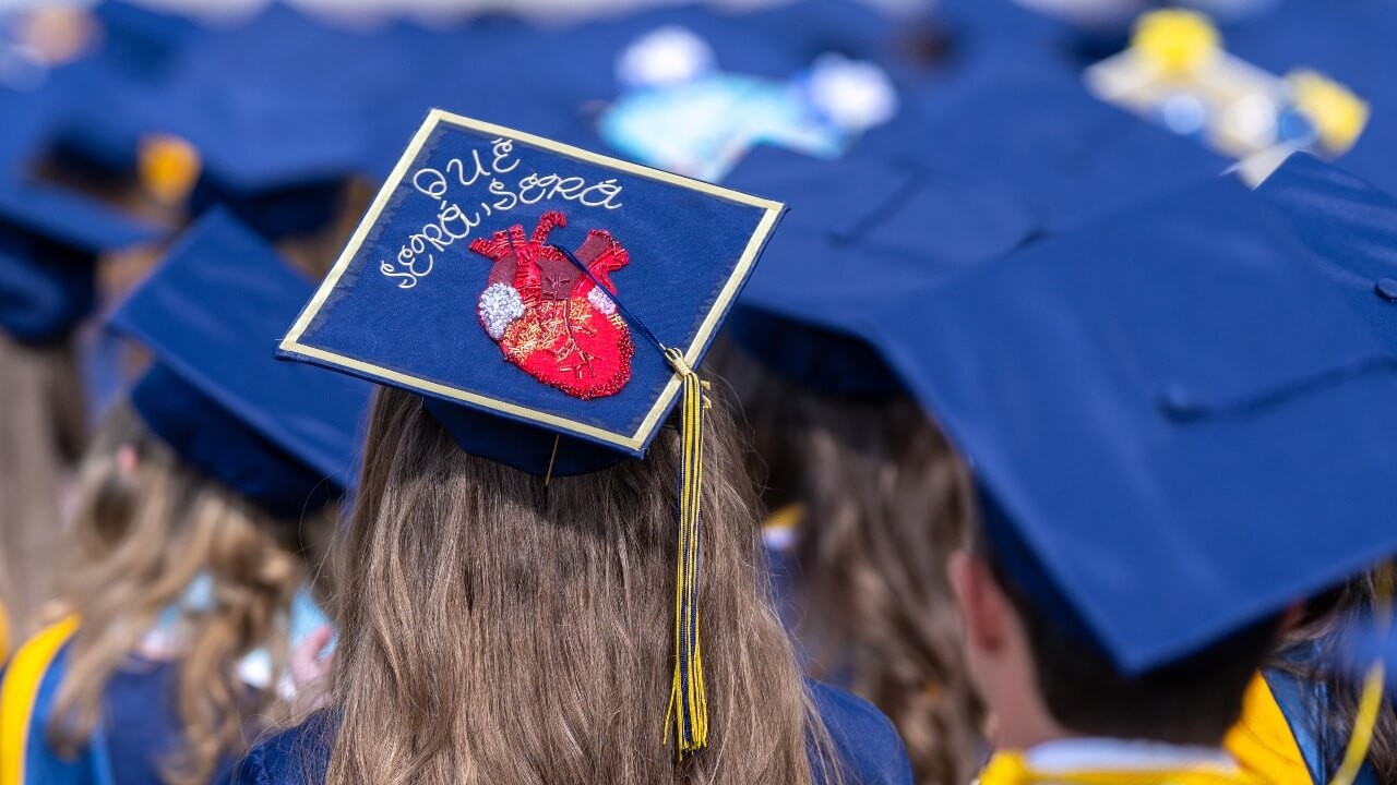 shot of a decorated cap with a heart image and the words "qué será, será"