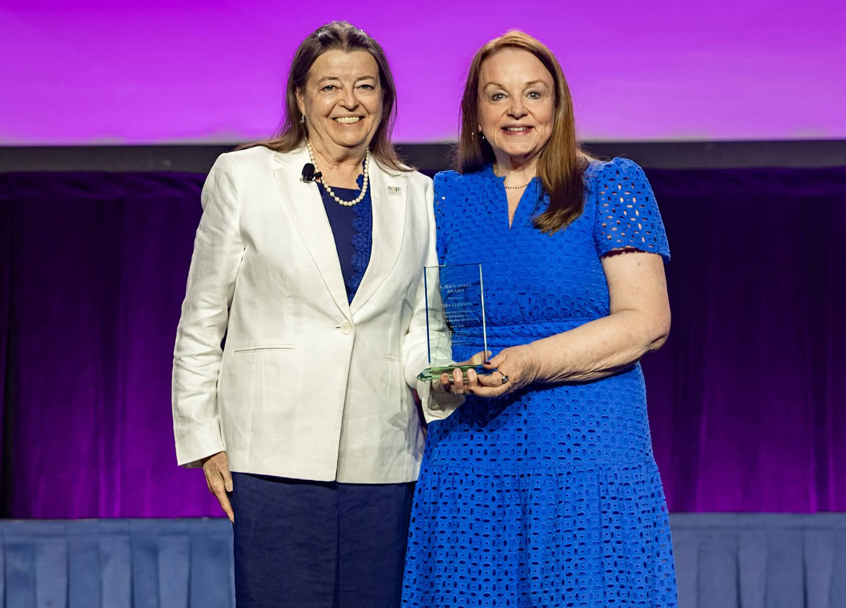 Individuals pose together on stage with award