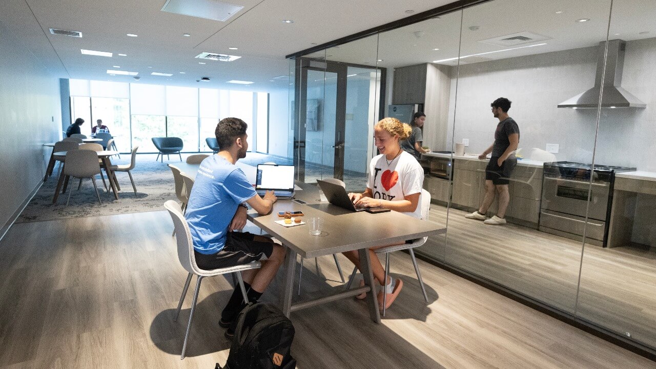 Students hanging out in the kitchen and lounge of The Grove