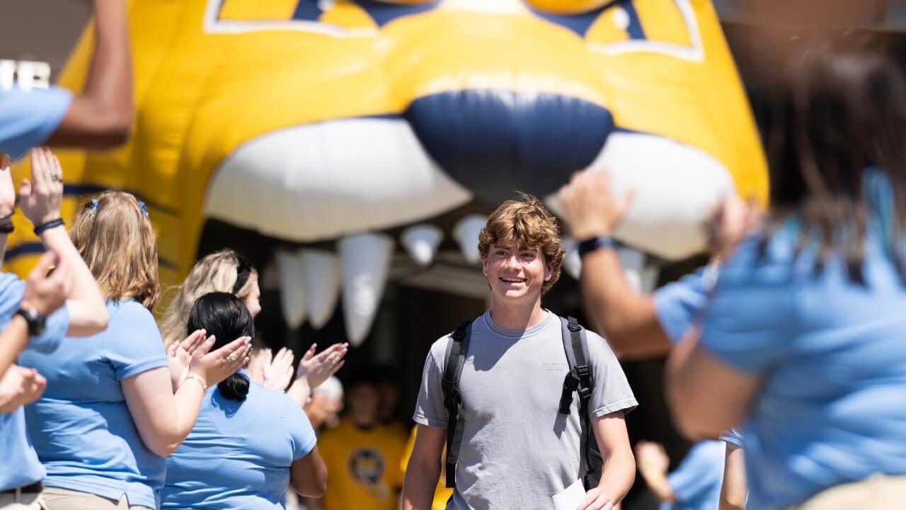 Student smiling while walking out of Orientation