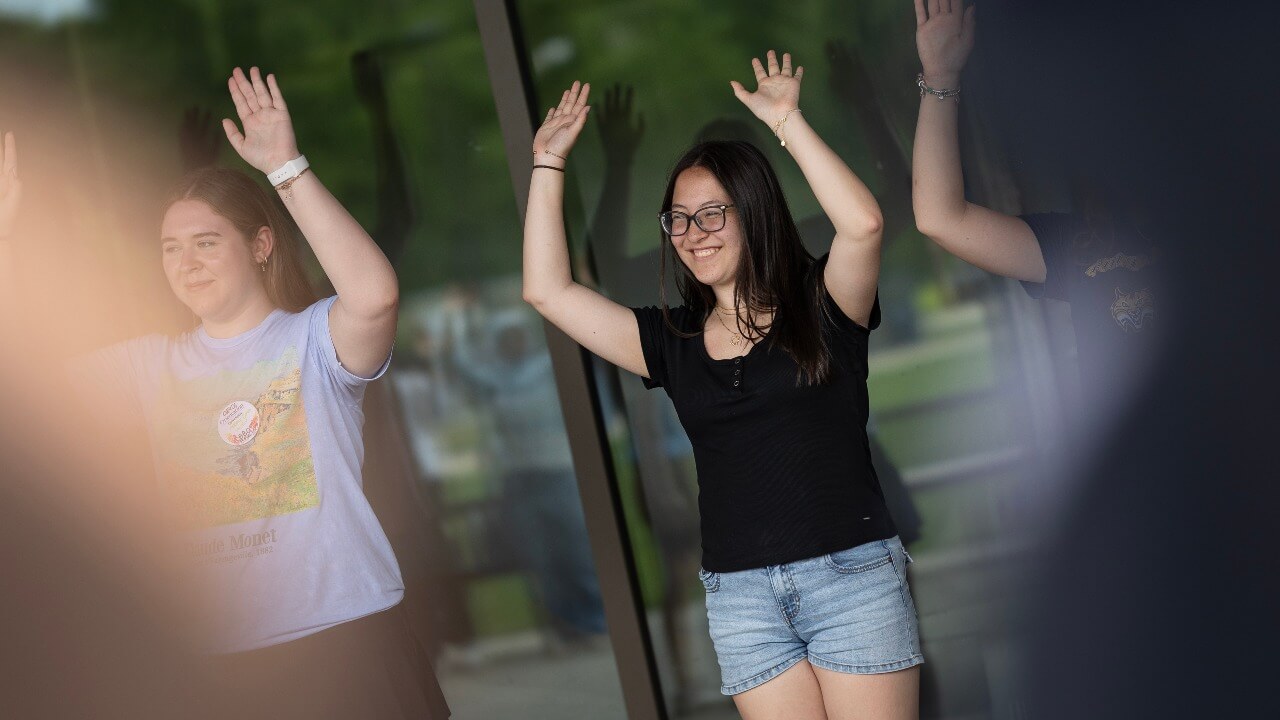 Students with their arms raised
