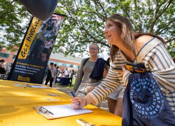 Student completing interest form at the Engagement Fair