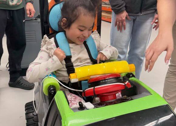 A child navigates a vehicle built as part of Go Baby Go