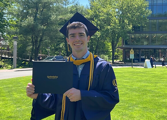Griffin Hunt '25 holding up his diploma at his graduation