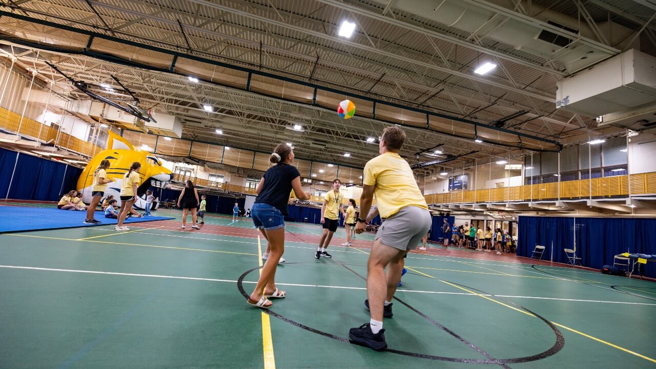 Wide shot of student and camper dancing