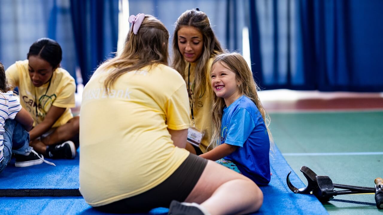 Student and camper sitting on mat